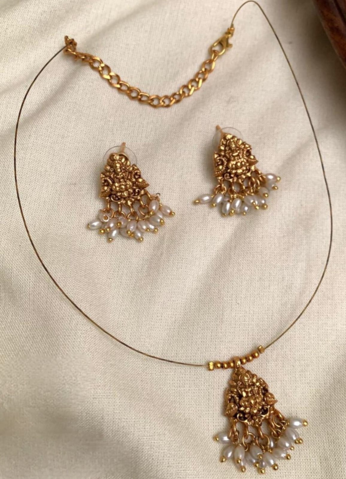 The Devika Set – Invisible Antique Gold Lakshmi Pendant with Pearl Drops: Antique Gold Matte Finish Lakshmi Pendant Set with Pearl Clusters | Minimalist Wire Choker & Matching Earrings